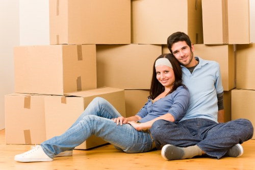 Household boxes and furniture being assessed for a cubic-yard quote